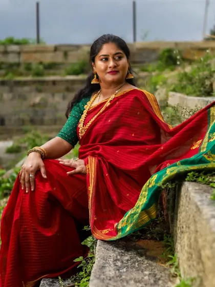 This shot, set against ancient stone, shows how a simple and elegant makeup look can be timeless. The focus is on clean skin and a defined lip, letting the traditional saree and setting shine.