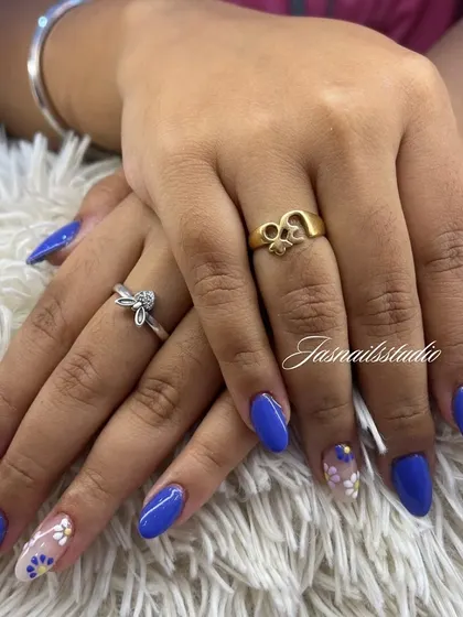 A beautiful royal blue manicure with delicate, hand-painted daisy accent nails. It's a simple way to add a touch of art to your look.