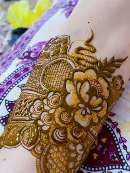 A close-up of the fresh henna paste, highlighting the 3D effect and intricate details of the floral design.