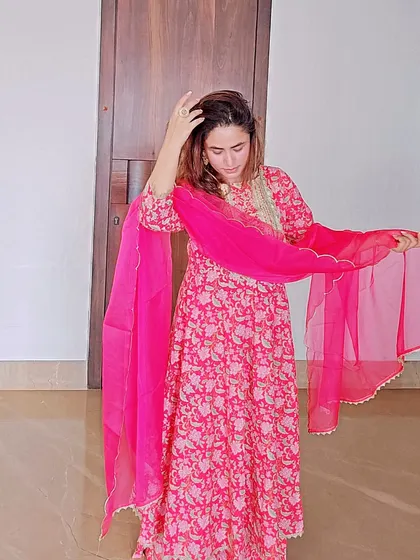 A floral printed Anarkali suit is both comfortable and incredibly chic. This vibrant pink ensemble is perfect for a festive lunch or a daytime ceremony, offering a beautiful flow and feminine charm.