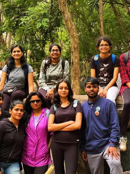 A larger group resting on a fallen log in the forest section of the Anthargange trail.