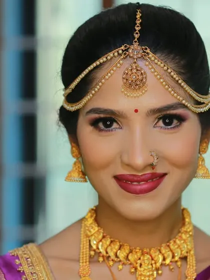A bright and clear bridal portrait, focusing on the bride's happy smile and stunning gold jewelry.