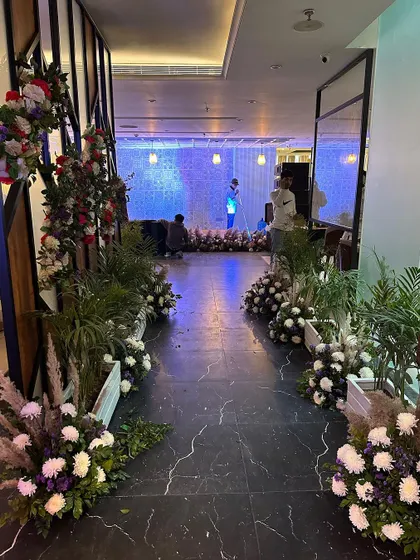 The decorated walkway leading into the restaurant, lined with floral arrangements.