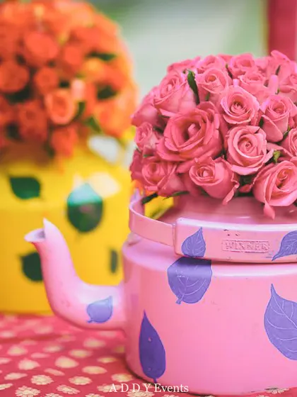 We love adding quirky and creative details to our decor. These hand-painted tea kettles, filled with bright pink and orange roses, served as fun and colorful centerpieces for a vibrant Mehndi event.