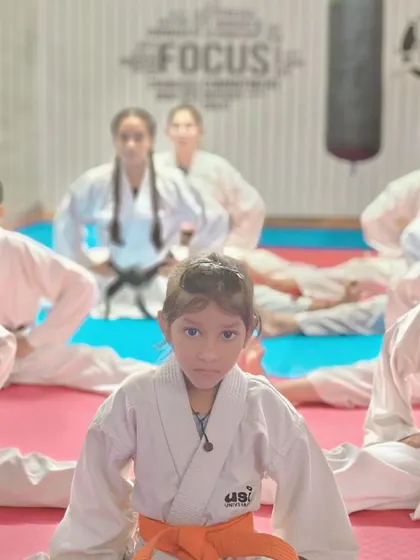 Focus is everything. A young karateka holds her stretching pose, building both physical and mental endurance.
