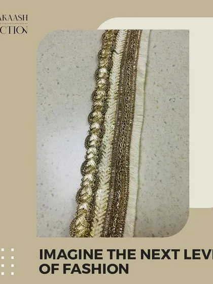 A close-up of a gold zari and threadwork lace. This type of textured, shimmering border is a classic choice for adding a touch of luxury to traditional Indian attire.