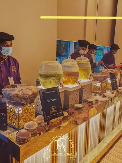 For an intimate corporate event, we created this clean and elegant Gol Gappa station. The setup features illuminated dispensers for our flavored waters and professional staff ready to serve, ensuring a seamless and high-end street food experience for all guests.