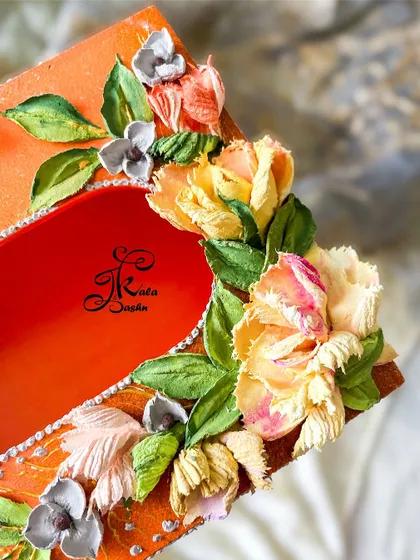 A tissue box with an ombre effect base, decorated with creamy, butter-textured flowers.