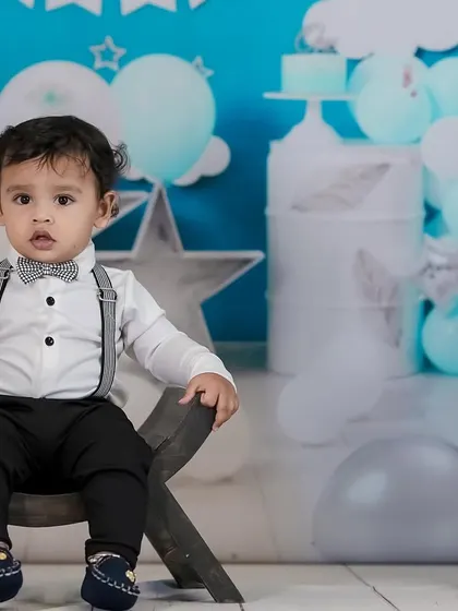 A classic first birthday portrait. This little boy looks so grown up sitting on the chair in his smart birthday outfit.