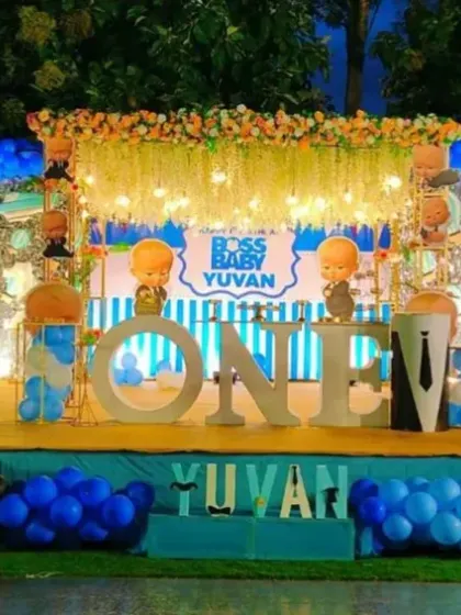 A grand outdoor Boss Baby setup for Yuvan's first birthday. The stage is decorated with character cutouts, balloon columns, and a large 'ONE' prop, creating a fantastic party zone.