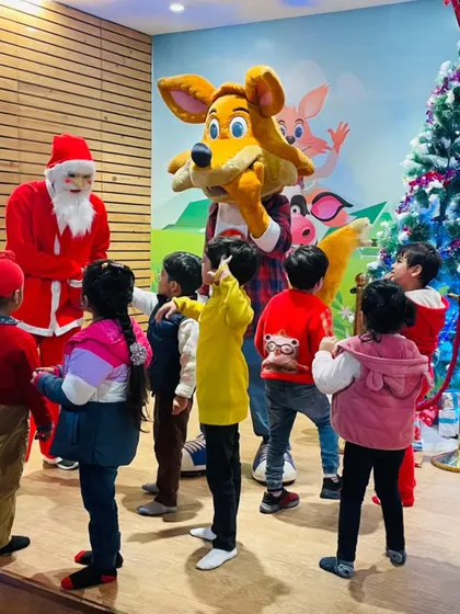 Children gather around Santa and J the Fox next to a Christmas tree. I transform the space into a winter wonderland to create a magical holiday experience for every visitor.