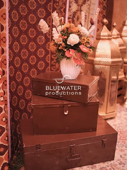 Old-fashioned metal trunks are stacked and used as a decorative element, topped with a floral arrangement.