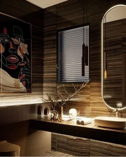 I designed this powder room to feel like a private, moody retreat. The space is defined by dark, book-matched marble walls, minimalist pendant lighting, and a custom backlit mirror that provides a soft glow. The modern art piece adds a bold, personal touch to this luxury washroom design.
