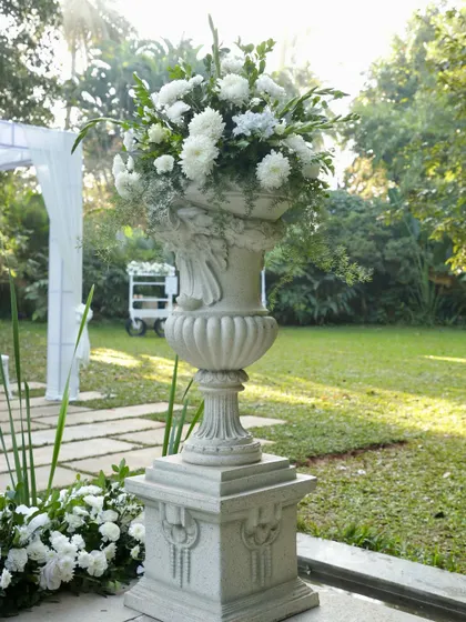 A close-up of a classical white urn overflowing with white chrysanthemums, a key element of our elegant decor style.