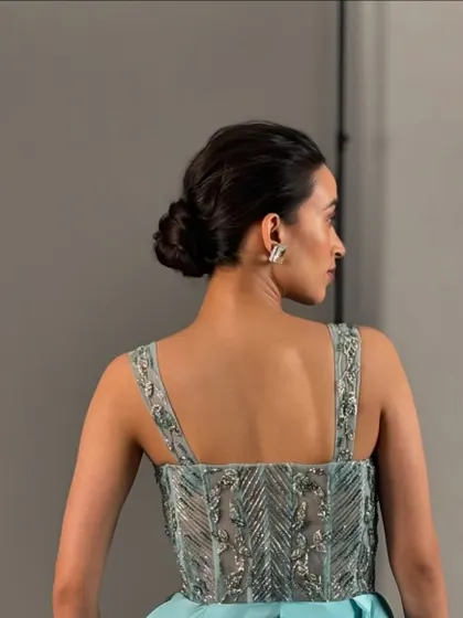 A view of the back, showcasing a classic and clean low bun. This updo is a versatile choice for any wedding event, as it's elegant, secure, and keeps hair neatly off the shoulders.