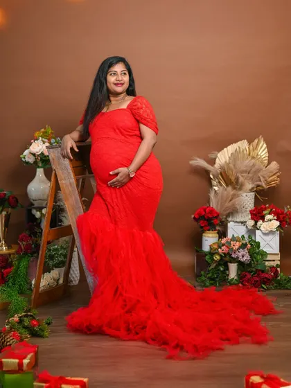 A full-length view of this gorgeous red gown. The mermaid cut is very flattering and adds a touch of glamour to the maternity shoot.