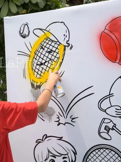 An interactive graffiti wall at a tennis-themed party, where kids can spray paint and color in tennis-related cartoons.