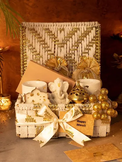 The epitome of festive luxury. This premium white and gold woven hamper is filled with a Ganesha idol, scented candles, and other elegant decor pieces for a truly special Diwali gift.