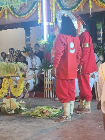 The performers praying to their anklets before the dance begins, a ritual to seek permission and blessings from the daiva.