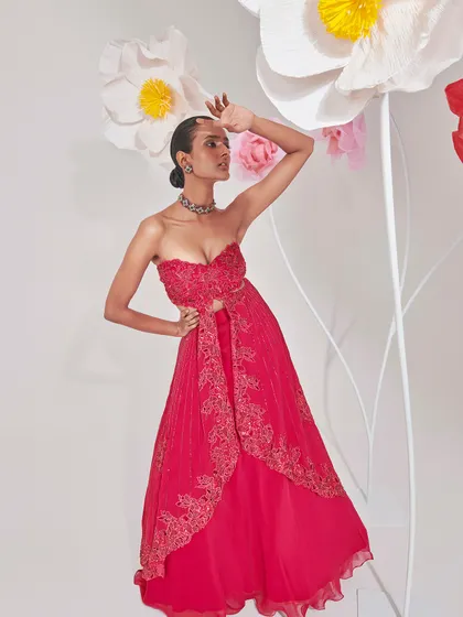 The full view of the red embroidered gown, showcasing its elegant drape and modern cut-out details.