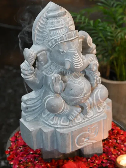 The intricate details of this Ganesha statue, a result of 'kai kelasa' (handiwork), are visible as incense smoke wafts by.