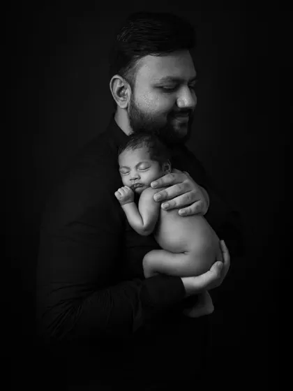 A father's gentle embrace. This black and white fine art portrait of a dad holding his sleeping newborn is full of tenderness and strength.