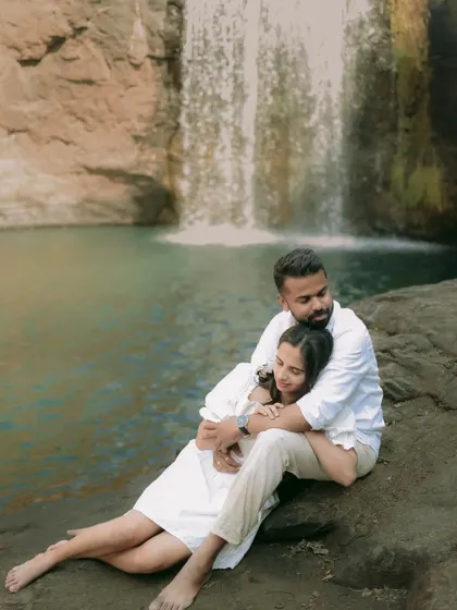 An intimate and cozy pose by the water, with the waterfall creating a serene and private atmosphere for the pre-wedding shoot.