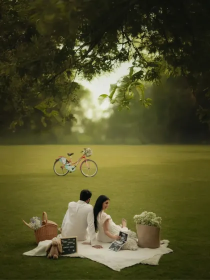 A wide shot of the romantic picnic setup, with a vintage bicycle adding a whimsical touch. This image showcases the beautiful, expansive outdoor locations we use for our styled shoots.