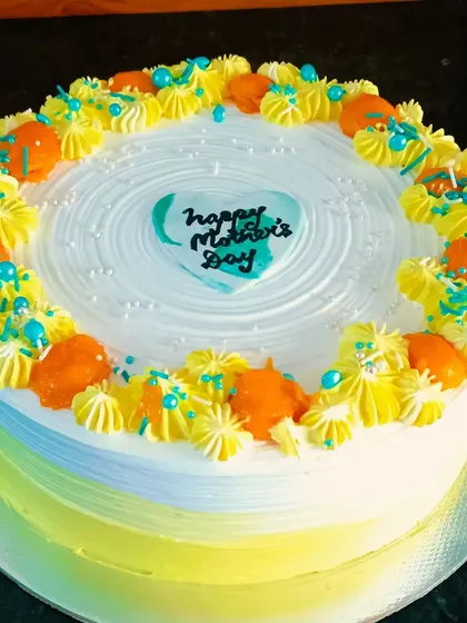 The beautiful yellow and white ombre on the mango cake, decorated with fresh mango pieces.