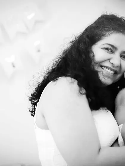 A joyful mother holds her newborn baby. This black and white at-home portrait is full of happiness and love.
