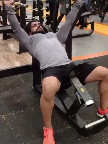 Performing an incline barbell press, a core exercise for developing the upper chest muscles. I guide clients on proper bench press technique for strength and size.