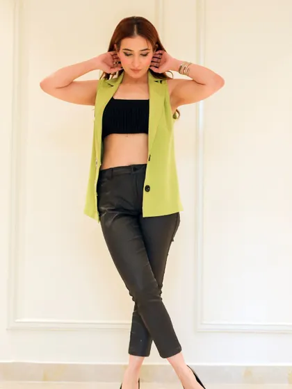 This shot captures a candid, styled pose, showing the outfit paired with a black crop top for a modern, edgy look.