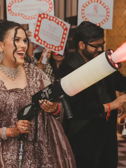 The bride having a blast with a CO2 gun. I love it when couples let loose and have fun at their own parties.