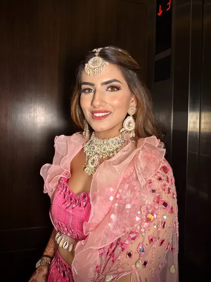 Carnival and Mehendi ready. This look is all about fun, with a bright pink outfit, glowing skin, and a playful, modern makeup style.