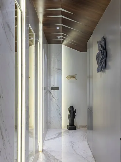 This hallway in The Filigree House showcases our attention to detail. A uniquely patterned wooden ceiling draws the eye upward, while integrated lighting and marble walls create a path of modern elegance.
