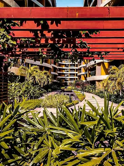 A view of the lush central courtyard at Palm Bellagio, seen through a red pergola.