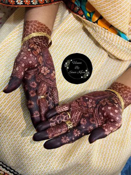 The rich, dark stain of a floral mehndi design, beautifully complemented by the client's rings. This is the result of pure, organic henna.
