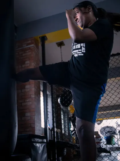 The power of a well-executed kick. Here, a student practices her technique on the heavy bag, a core part of building strength and conditioning for self-defence.