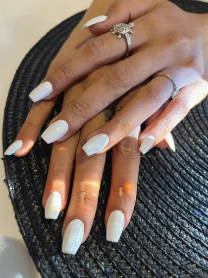 A clean and crisp set of glossy white nails. This timeless color looks amazing with a tan and is perfect for a fresh, polished look on these coffin-shaped extensions.