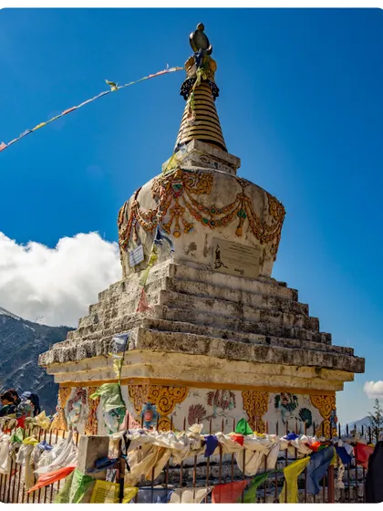 A classic Buddhist stupa along the EBC trail, adorned with prayer flags. These spiritual markers are a common sight, offering blessings to travelers in the Himalayas.