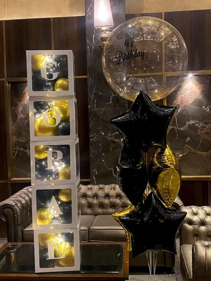 The full view of the custom balloon cubes and bouquet. This black and gold theme is a popular choice for sophisticated and modern birthday celebrations.