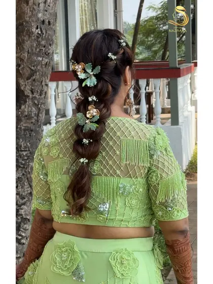 The back of this beautifully accessorized braid, perfect for a bride who wants a unique and whimsical Mehendi hairstyle.