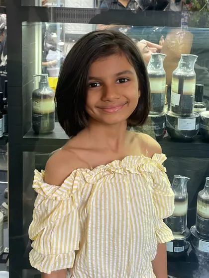 This young client is glowing with her new short bob. The cut is clean and chic, perfectly framing her smiling face.
