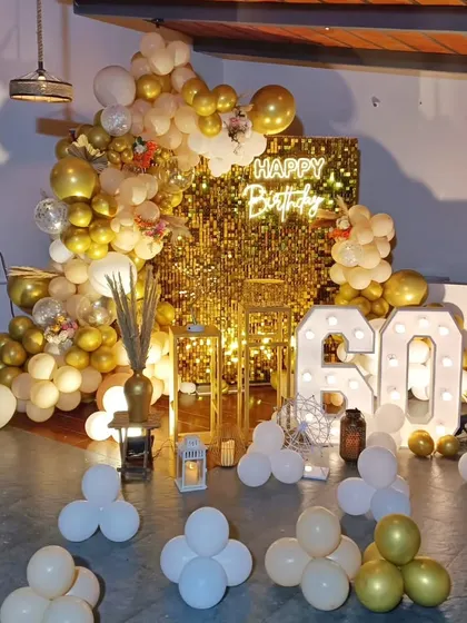 A glamorous 60th birthday celebration. The gold sequin wall, massive balloon arrangement, and large light-up numbers create a truly spectacular and festive setting.