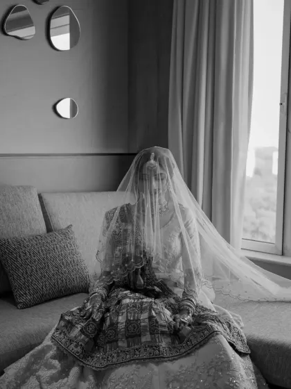 A full-length black and white shot of the bride under her veil, creating a timeless and classic image.