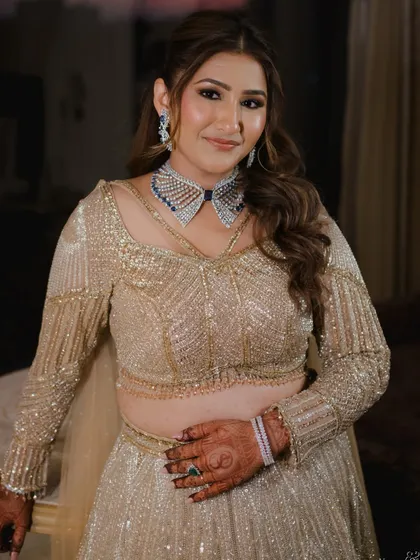 A voluminous half-up ponytail adds a touch of Hollywood glam to this sangeet look. It's a great style for creating drama and movement.
