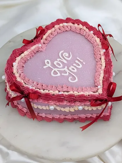 A still shot of our beautiful vintage heart cake. The layered, frilly piping and "Love You!" message make it a perfect cake for anniversaries, Valentine's Day, or just because.