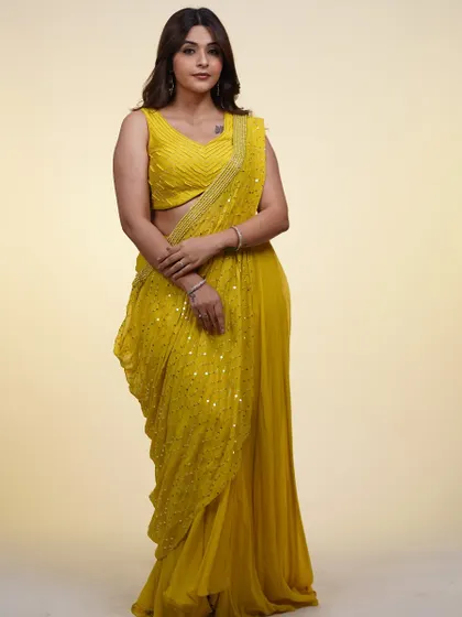 The full look of the yellow draped saree. It's a modern, easy-to-wear outfit that's perfect for a haldi ceremony or a summer wedding.