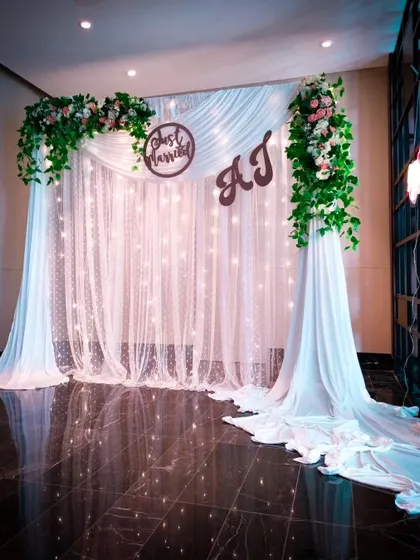 Celebrate your new beginning with an elegant "Just Married" backdrop. I use beautiful white drapes, fairy lights, and custom wooden signs with your initials to create a perfect photo spot for the happy couple.