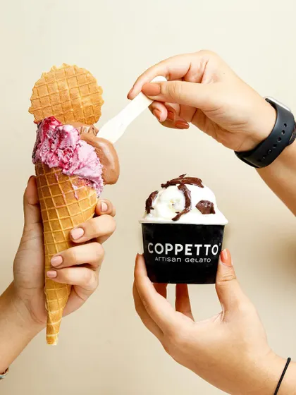 A fun and interactive shot featuring two hands sharing artisan gelato. This type of image captures a moment of joy and connection, making the product feel like a shared experience.